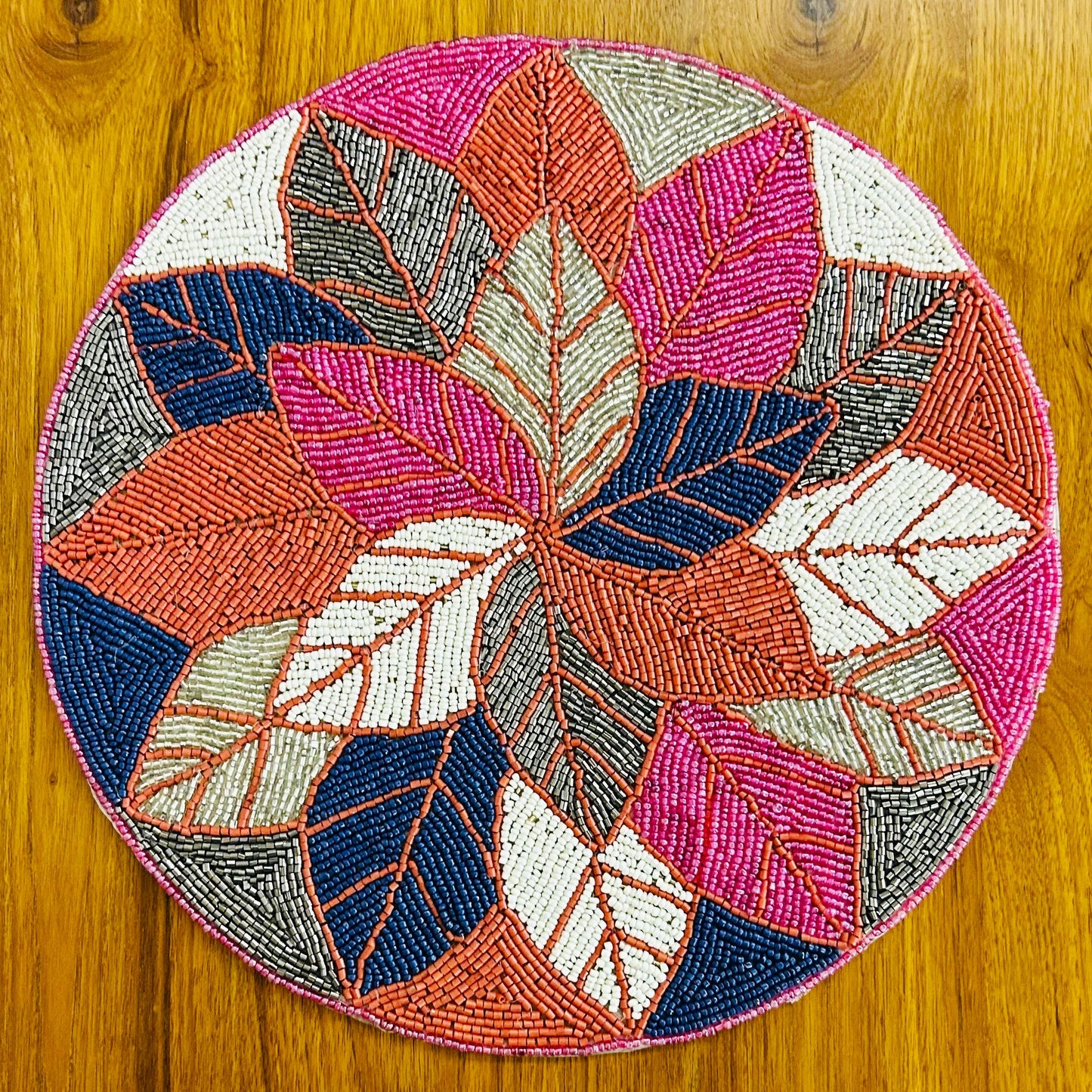 Round beaded placemat with leaf pattern